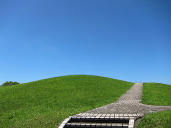 Scenic view of a hill against clear blue sky