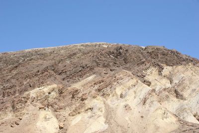 Low angle view of desert against clear blue sky