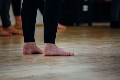 Low section of women standing on hardwood floor