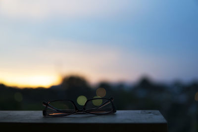 Close-up of eyeglasses on sunglasses at sunset