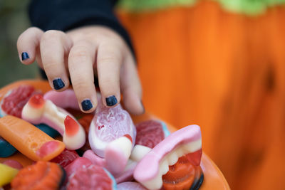 Halloween background. children's hands reach for the scary candy on the plate