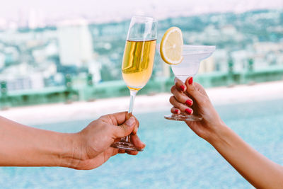 Midsection of woman holding wine glass