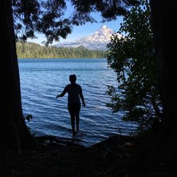 Silhouette of man in water against sky