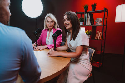 Portrait of smiling friends sitting at home