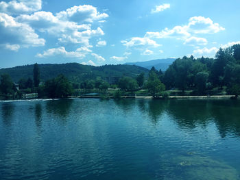 Scenic view of lake by trees against sky