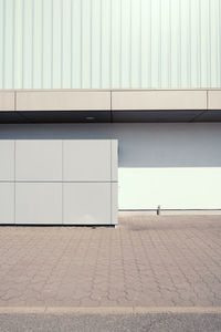 Footpath by wall against building in city