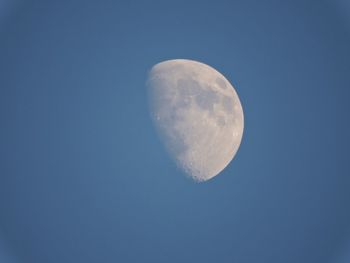 Low angle view of moon against blue sky at night