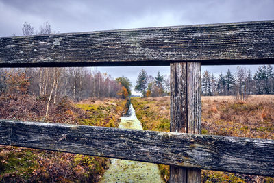 View of wooden fence on field against sky