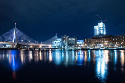 Leonard p zakim bunker hill memorial bridge over river against illuminated cityscape