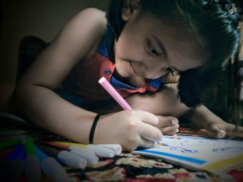 Close-up of girl coloring on book at home