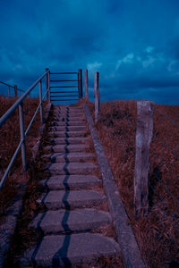 Staircase on footpath against sky