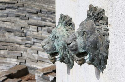 Statue of two lion face on the wall in a water fountain in japan