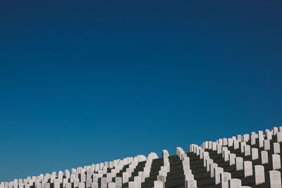 Low angle view of thomb stones against clear blue sky