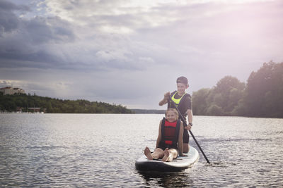 Brother and sister paddle boarding