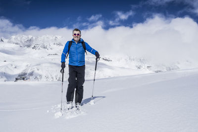 Full length of smiling man standing on snow covered landscape