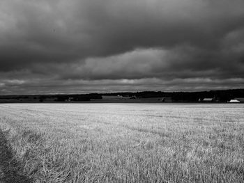 Scenic view of field against cloudy sky