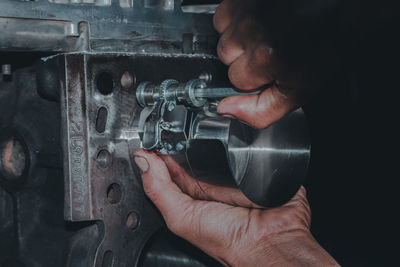 Cropped hand of man repairing machinery