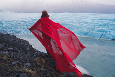 Lady with waving fabric on rock scenic photography