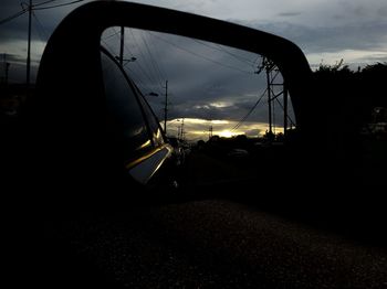 Silhouette of car on road at sunset