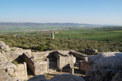 View of old ruins on landscape against sky