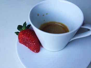 Close-up of strawberry and coffee cup on table