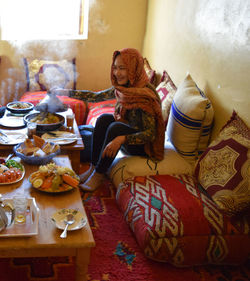 Woman sitting on table at home