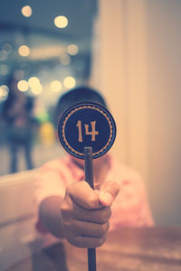 Close-up of boy holding information sign