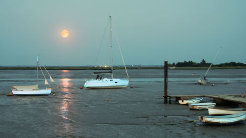 Boats moored in sea against clear sky