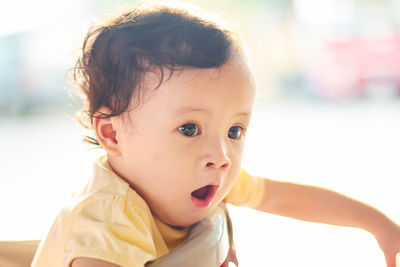 Close-up of cute baby girl yawning at home