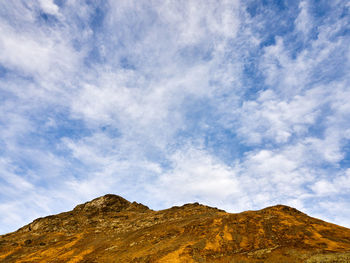 Beautiful cloudy sky with a mountain lit by sunset light, martian landscape