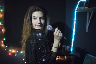 Young woman singing at band rehearsal