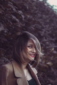 Portrait of smiling young woman in forest