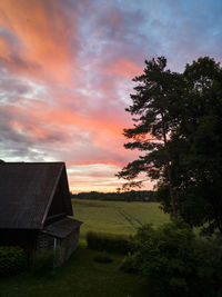 House on field against sky during sunset