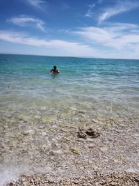 Man in sea against sky