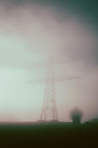 Low angle view of electricity pylon against sky during sunset