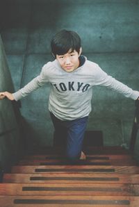 Portrait of boy standing on staircase