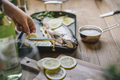 Midsection of woman holding fruit on table