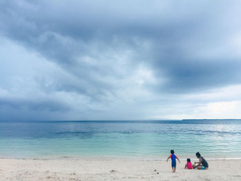 People at beach against sky