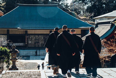 Rear view of people walking outside building