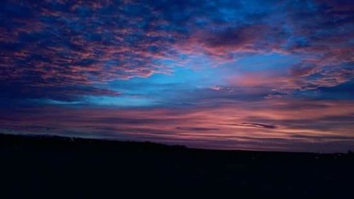 Silhouette of landscape against cloudy sky