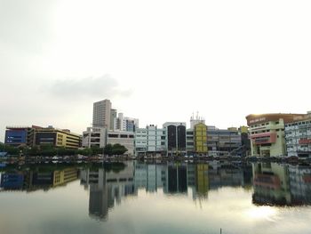 Reflection of buildings in city against sky