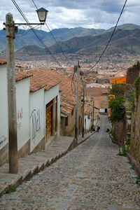 Street amidst houses in town against sky