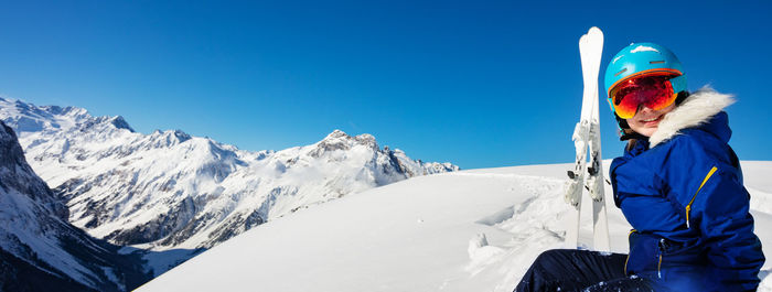 Rear view of man standing on snowcapped mountain