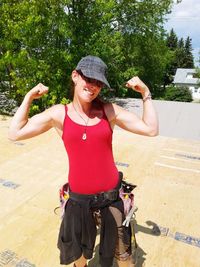 Young woman smiling while standing on tree