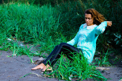 Young woman sitting against rock formation