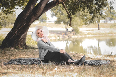 Side view of woman sitting on field