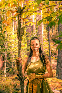 Portrait of woman standing against trees
