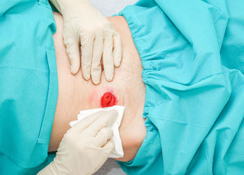 Midsection of woman with iv drip on bed