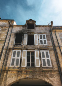 Low angle view of abandoned building against sky