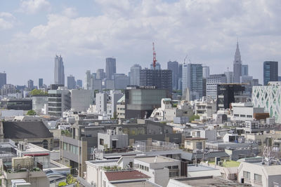 View of cityscape against cloudy sky